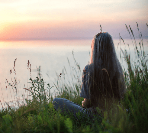 Woman sitting calmly by sunset