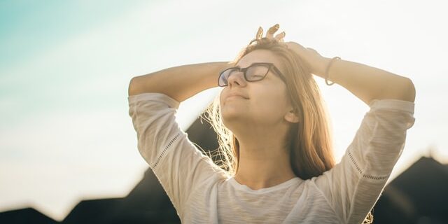Woman in glasses with closed eyes outside